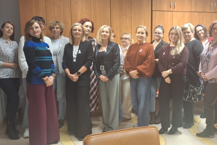 Na zdjęciu znajduje się grupa piętnastoosobowa mająca na sobie przyczepione białe wstążki.