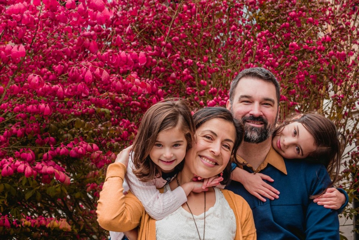Na zdjęciu znajduje się Rodzina uśmiechająca się do aparatu.