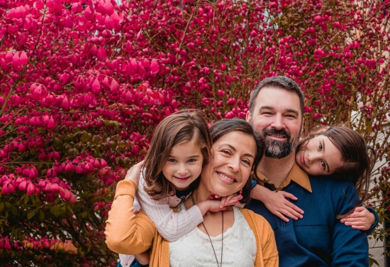 Na zdjęciu znajduje się Rodzina uśmiechająca się do aparatu.