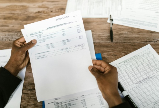 Osoba trzyma dokument najprawdopodobniej analizuje go